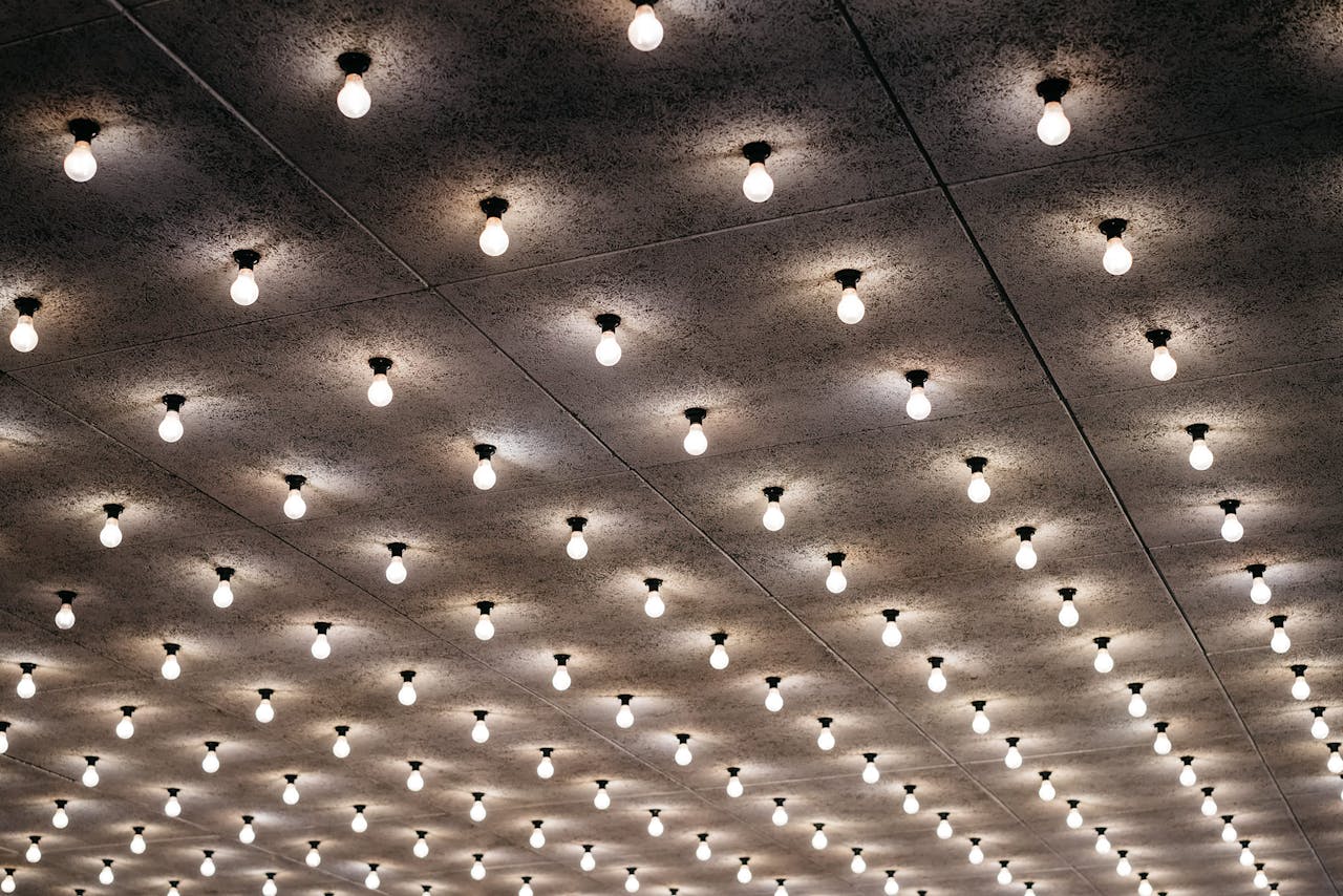 Aerial view of ceiling with numerous retro light bulbs glowing in a grid pattern.